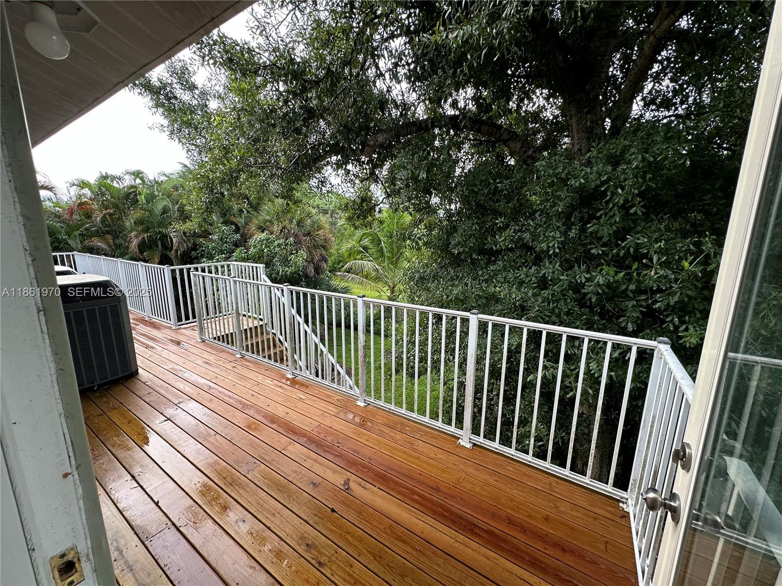 5548 Birdsong Lane, Unit 1 Bokeelia, FL 33922 - Photo 16 of 24 a view of balcony with wooden floor and fence