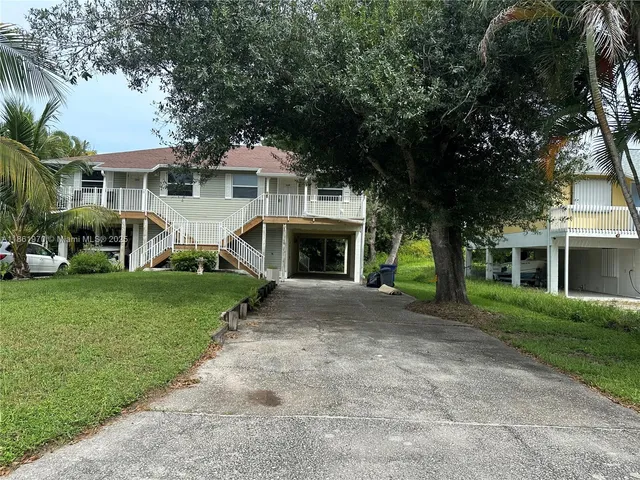 front view of a house with a yard and an trees