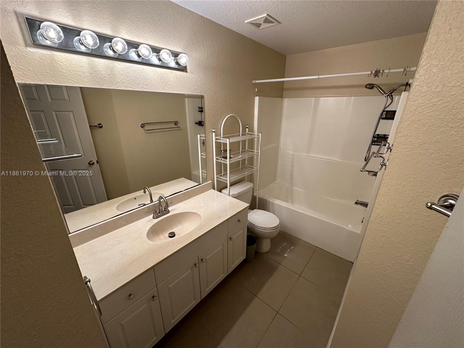 5548 Birdsong Lane, Unit 1 Bokeelia, FL 33922 - Photo 21 of 24 a bathroom with a sink a toilet a mirror and shower