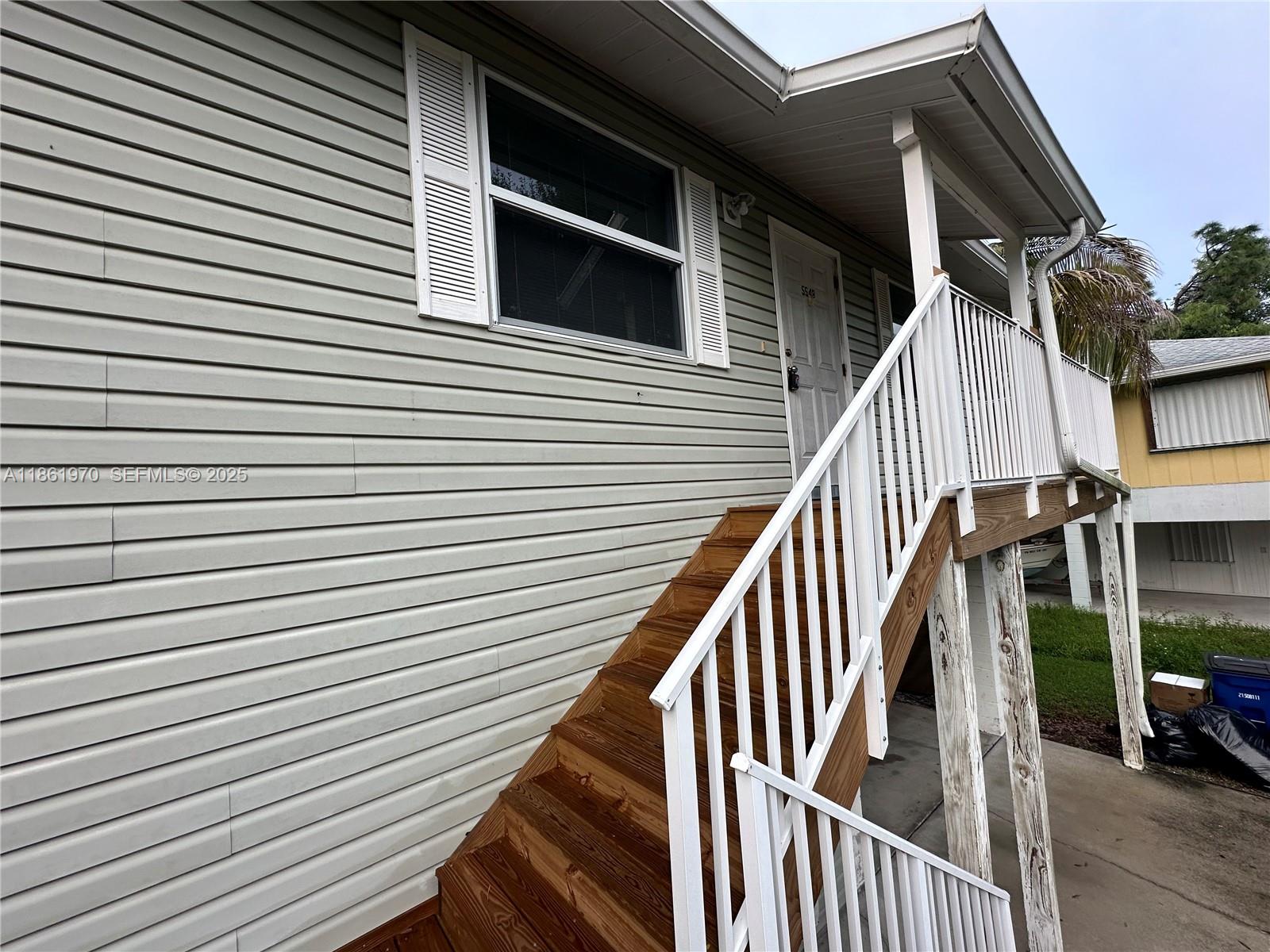 5548 Birdsong Lane, Unit 1 Bokeelia, FL 33922 - Photo 24 of 24 a view of a house with wooden deck