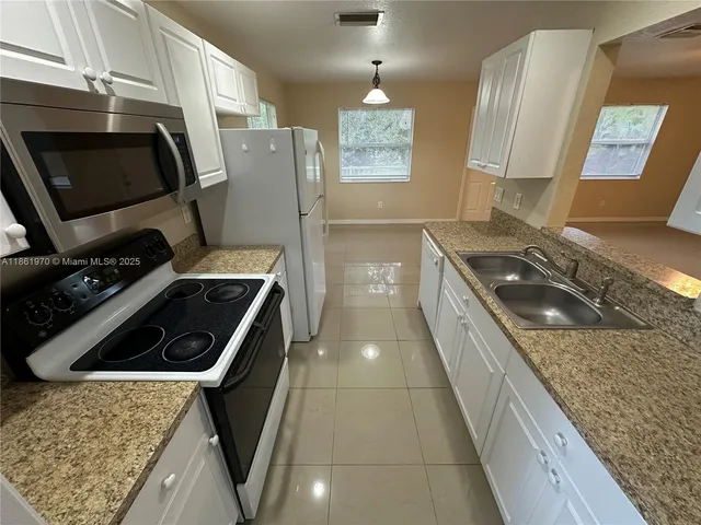 a kitchen with granite countertop a stove and a refrigerator