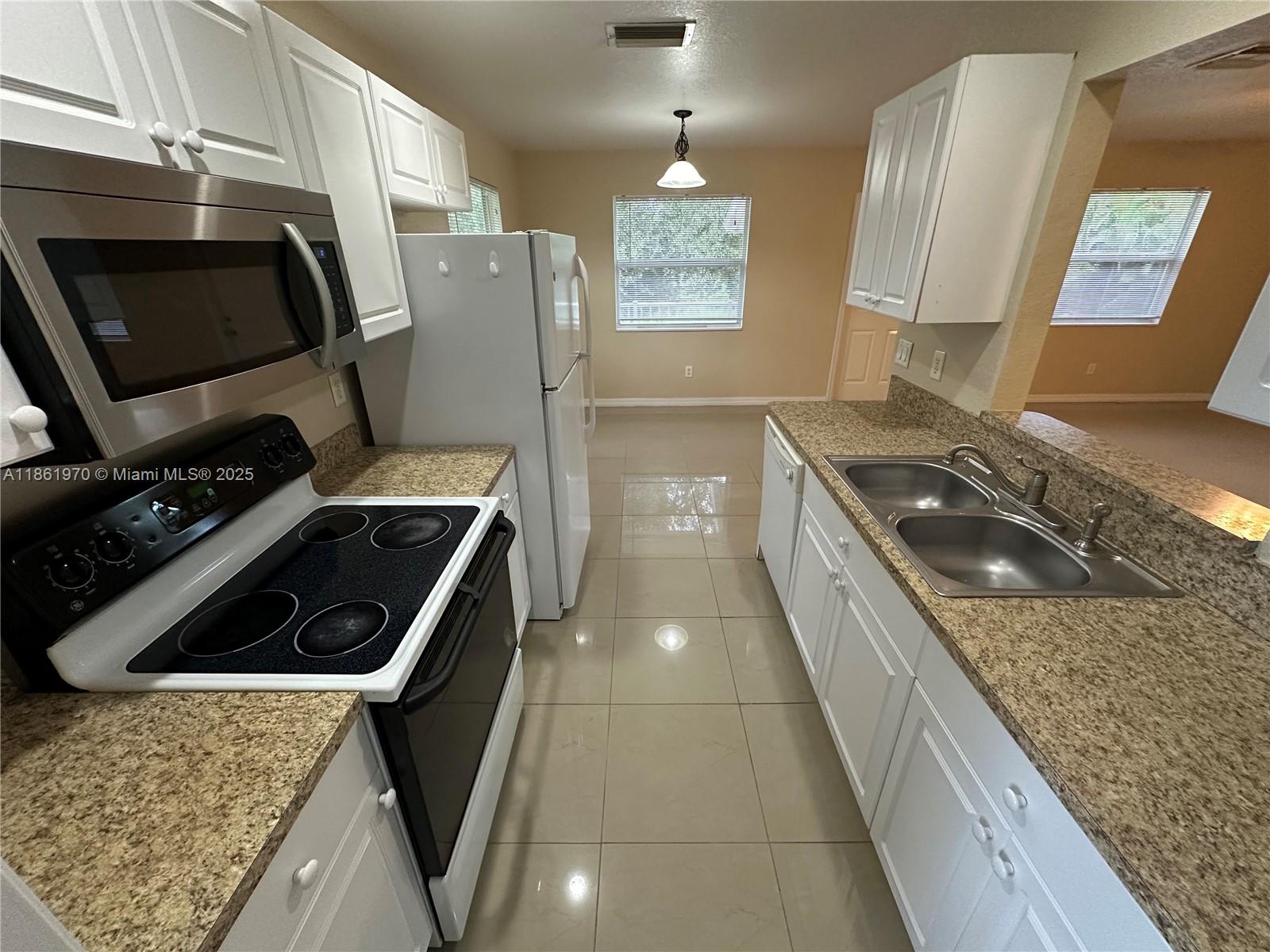 5548 Birdsong Lane, Unit 1 Bokeelia, FL 33922 - Photo 9 of 24 a kitchen with granite countertop a stove and a refrigerator