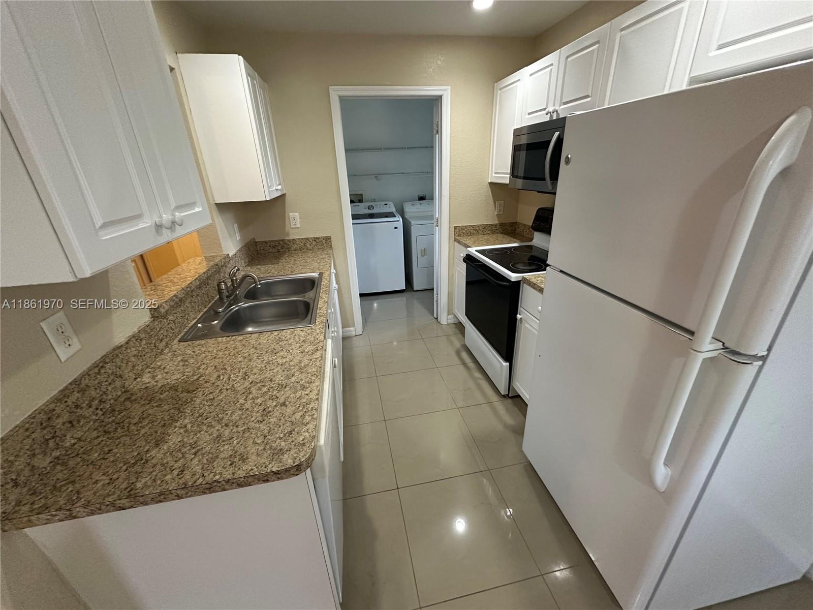 5548 Birdsong Lane, Unit 1 Bokeelia, FL 33922 - Photo 10 of 24 a kitchen with granite countertop a refrigerator and a sink