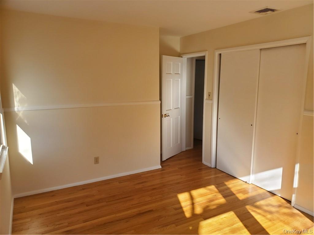 215 Harriman Road Irvington, NY 10533 - Photo 12 of 20 Unfurnished bedroom with visible vents, light wood finished floors, baseboards, and a closet