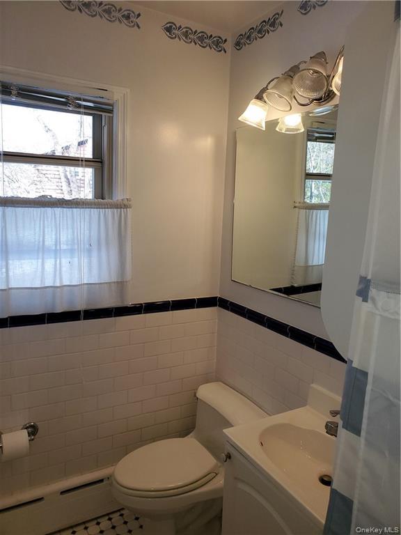 215 Harriman Road Irvington, NY 10533 - Photo 16 of 20 Bathroom with toilet, tile patterned floors, tile walls, and a healthy amount of sunlight