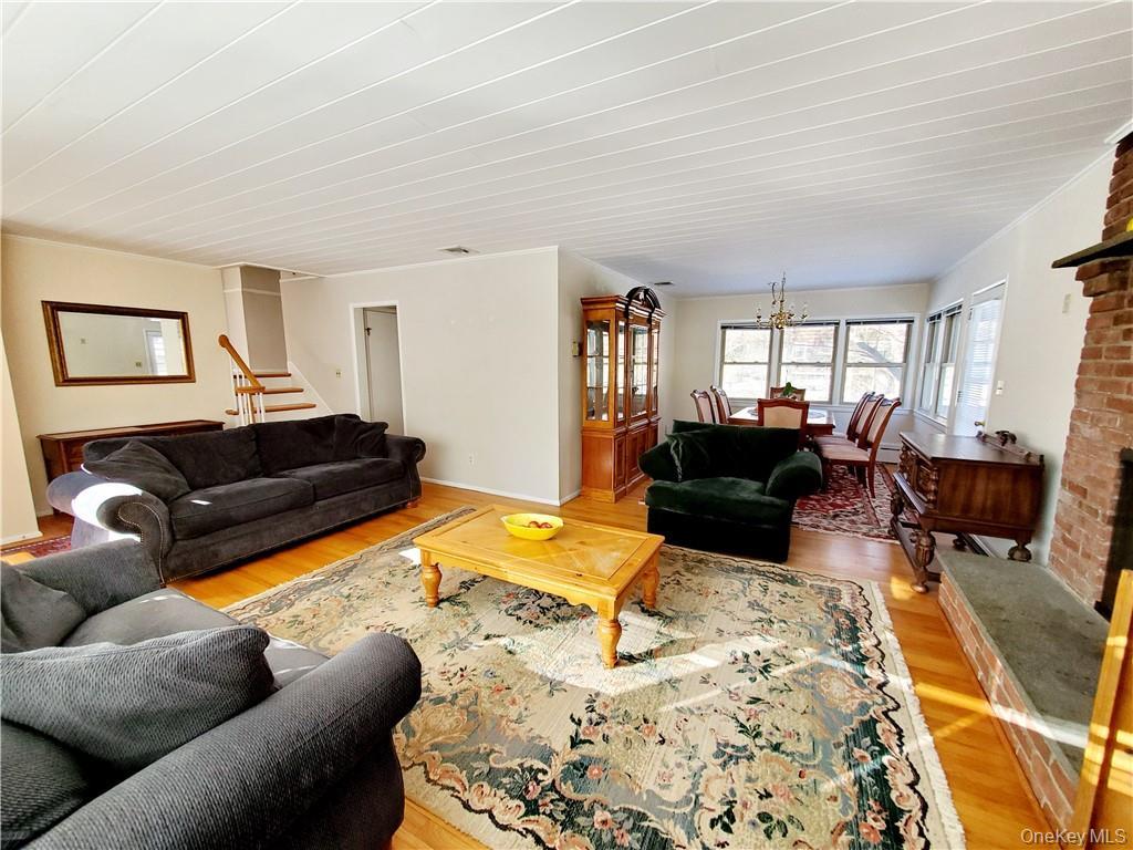 215 Harriman Road Irvington, NY 10533 - Photo 3 of 20 Living room featuring stairs, an inviting chandelier, and light wood finished floors