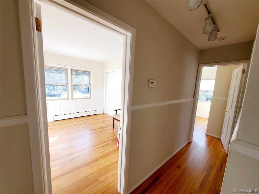 215 Harriman Road Irvington, NY 10533 - Photo 9 of 20 Corridor with a baseboard heating unit, track lighting, and light wood-type flooring