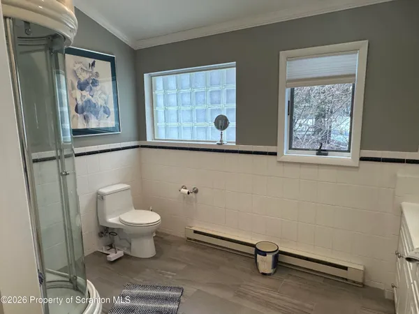 a bedroom with a bed a dresser and potted plants