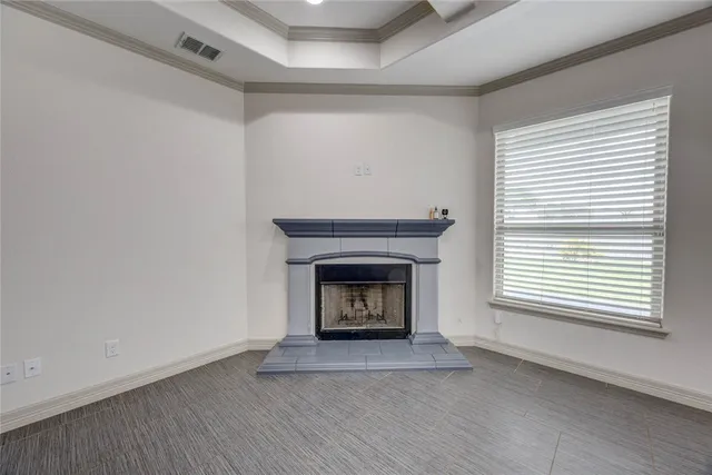 a view of an empty room with a fireplace and a window