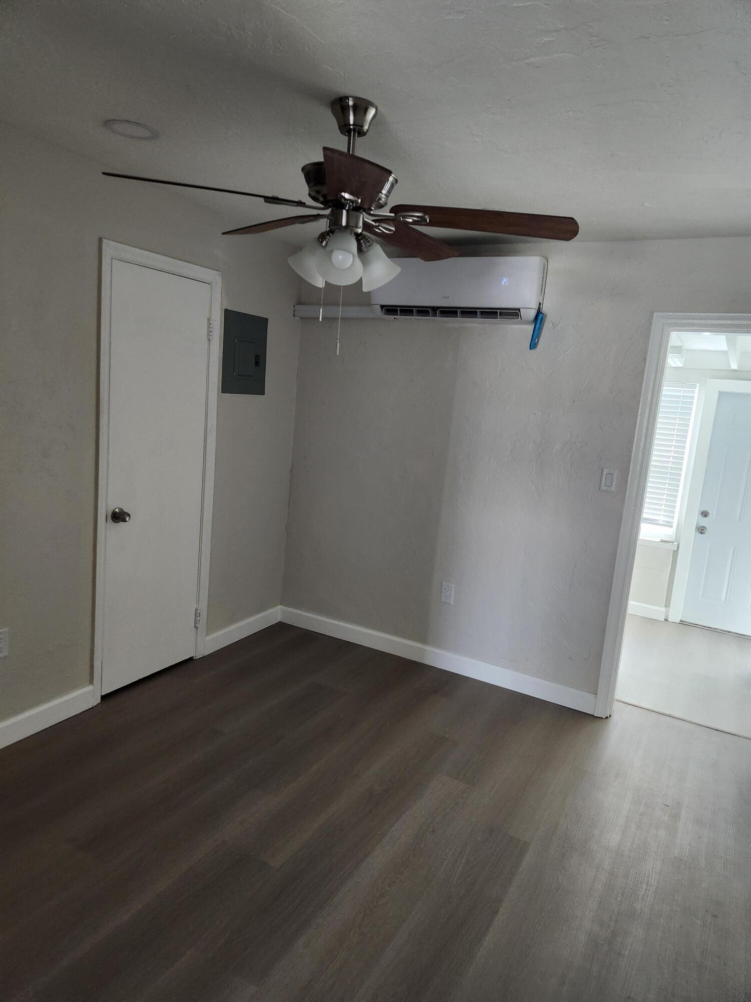 65 West 34th Street, Unit B Riviera Beach, FL 33404 - Photo 4 of 13 a view of a room with wooden floor cabinet and a ceiling fan