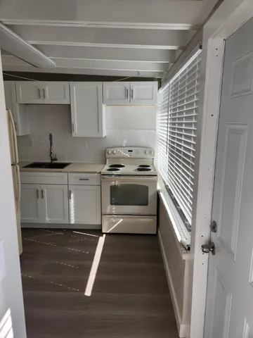 a kitchen with granite countertop a sink a stove and cabinets