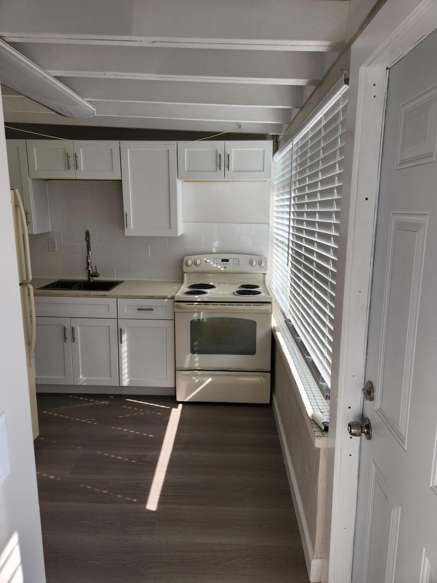 65 West 34th Street, Unit B Riviera Beach, FL 33404 - Photo 7 of 13 a kitchen with granite countertop a sink a stove and cabinets