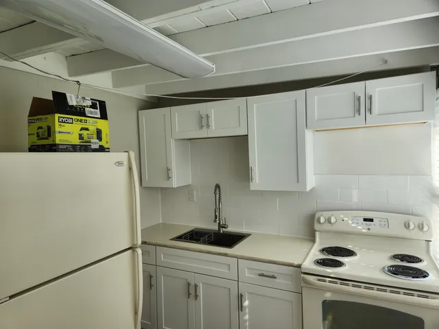 a kitchen with a refrigerator a stove a sink a washer and dryer