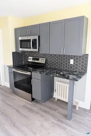 a kitchen with stainless steel appliances granite countertop a stove a microwave and a sink