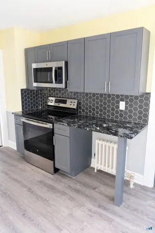 a kitchen with stainless steel appliances granite countertop a stove a microwave and a sink