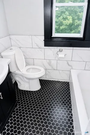 a bathroom with a toilet a window and a shower