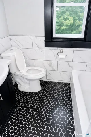 a bathroom with a toilet a window and a shower