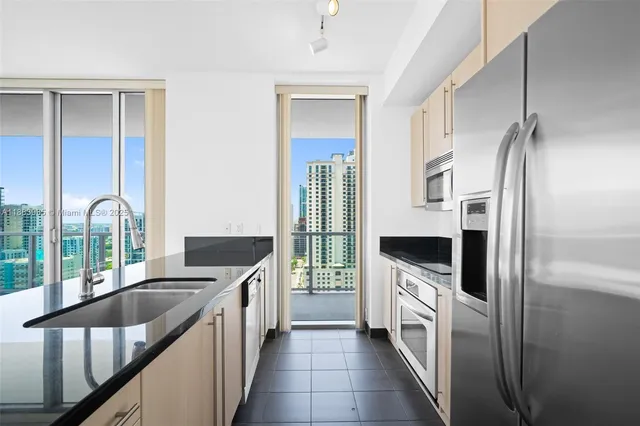 a kitchen with stainless steel appliances granite countertop a refrigerator and a stove