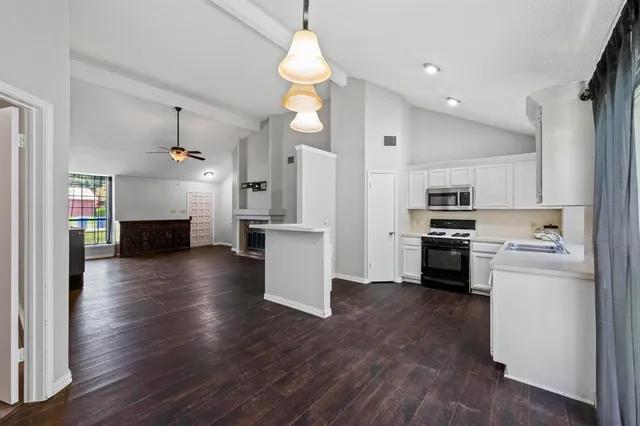a kitchen view with stainless steel appliances wooden floor and a kitchen view