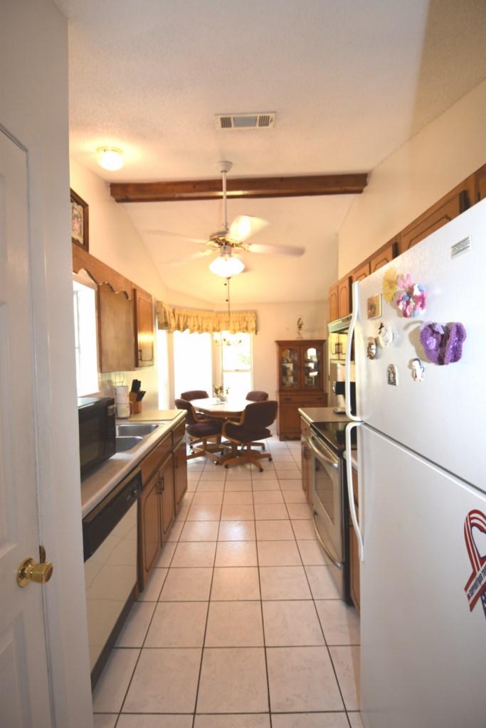 2840 Old Mill Way Crestview, FL 32539 - Photo 17 of 35 a kitchen with a sink a refrigerator and a stove