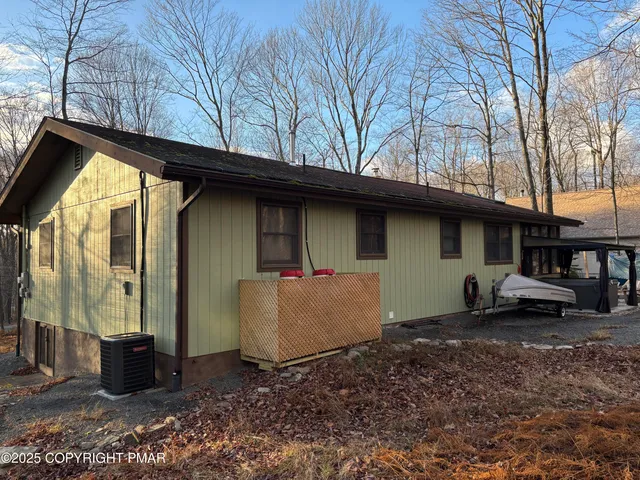 a view of a house with a large tree and wooden fence