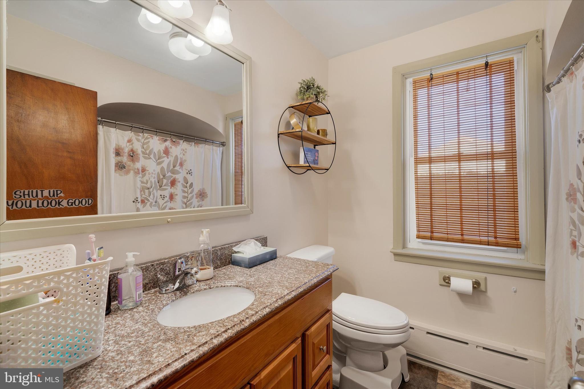 570 Oysterdale Road Oley, PA 19547 - Photo 9 of 26 a bathroom with a granite countertop toilet a sink and a mirror