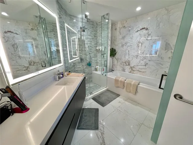 a bathroom with a tub sink shower and a mirror