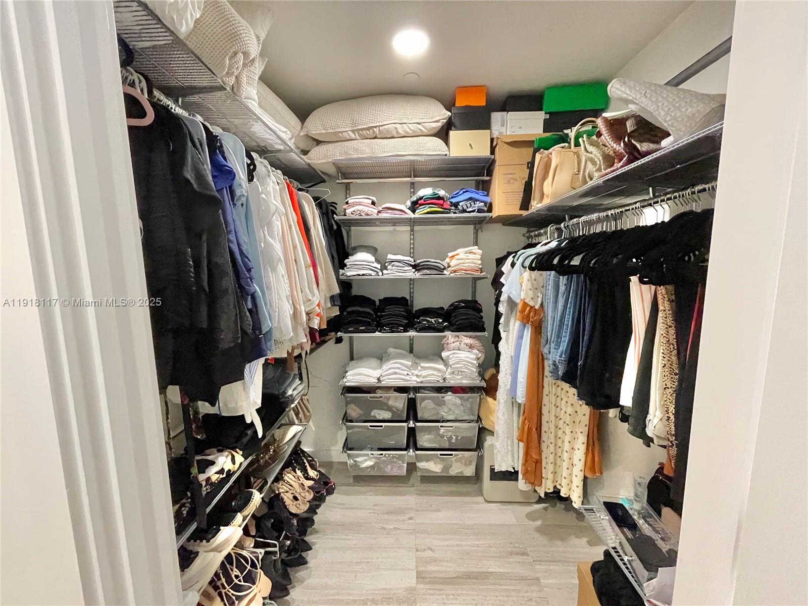 851 Northeast 1st Avenue, Unit 2605 Miami, FL 33132 - Photo 16 of 49 a view of walk in closet with clothes and shoes