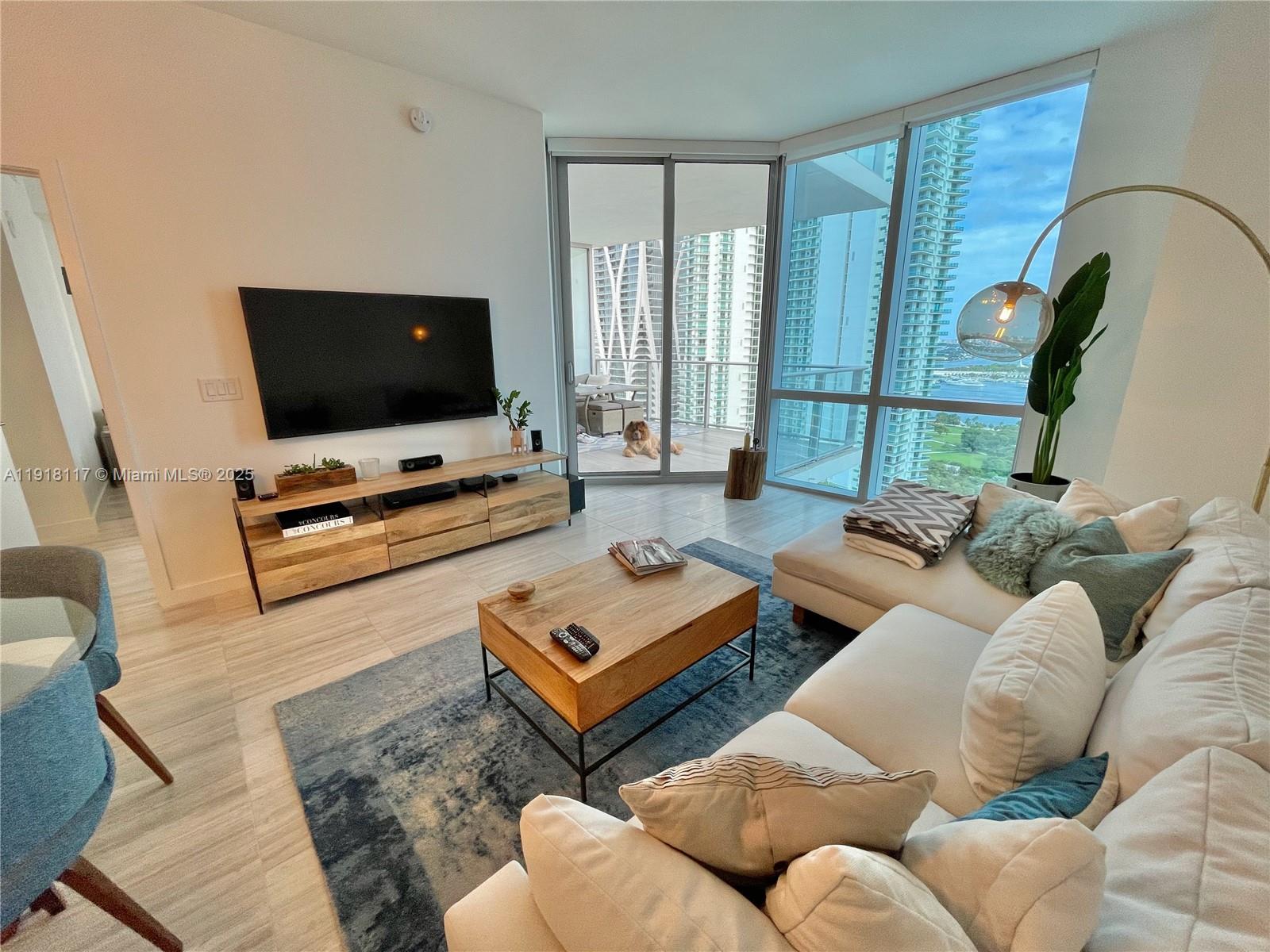 851 Northeast 1st Avenue, Unit 2605 Miami, FL 33132 - Photo 22 of 49 a living room with furniture and a flat screen tv