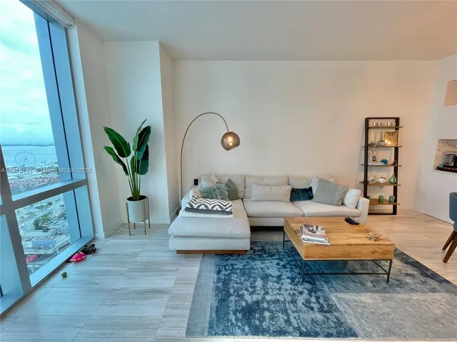 a living room with furniture wooden floor and a large window