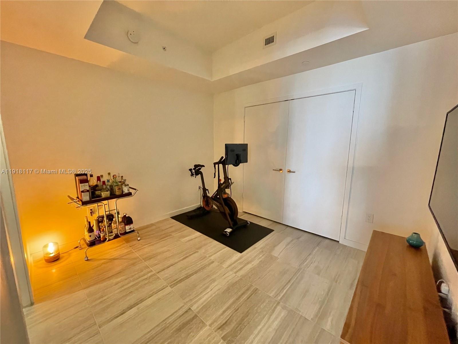 851 Northeast 1st Avenue, Unit 2605 Miami, FL 33132 - Photo 38 of 49 a room with gym equipment and wooden floor