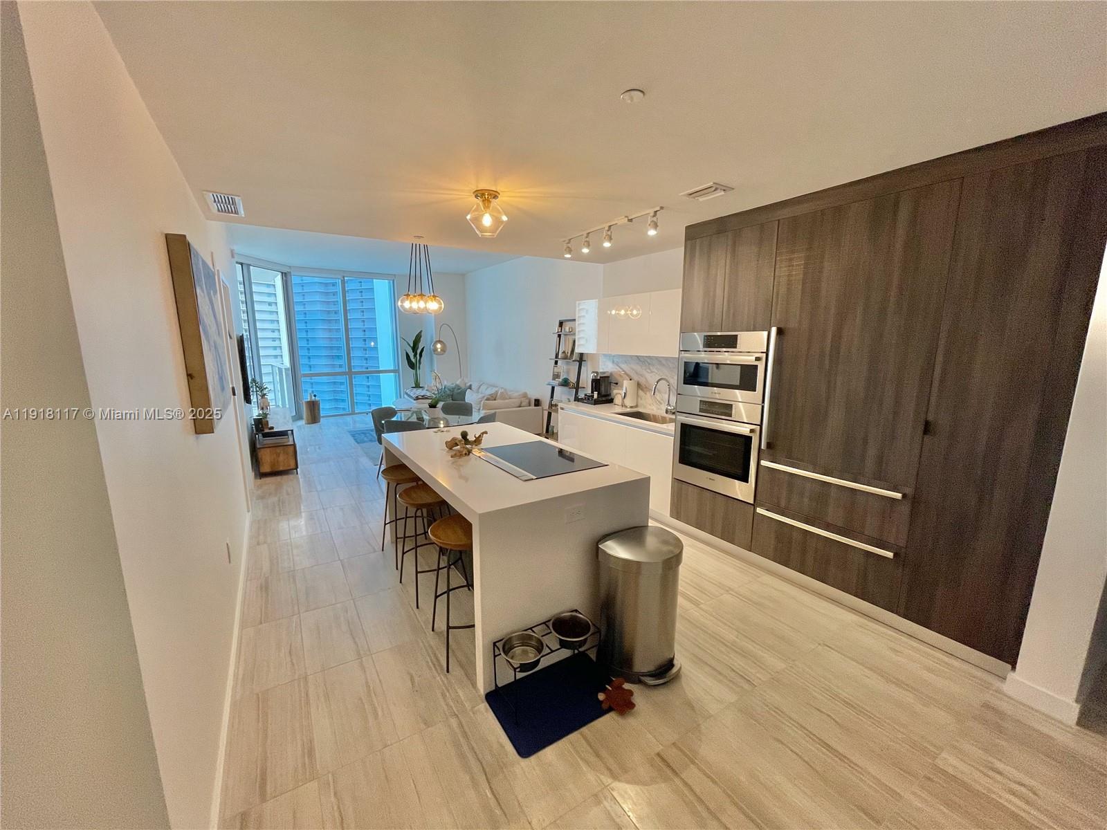 851 Northeast 1st Avenue, Unit 2605 Miami, FL 33132 - Photo 42 of 49 a kitchen with a sink appliances and cabinets