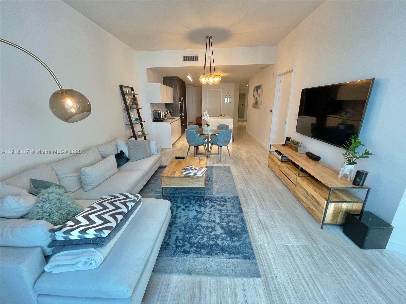 851 Northeast 1st Avenue, Unit 2605 Miami, FL 33132 - Photo 8 of 49 a living room with furniture and a flat screen tv