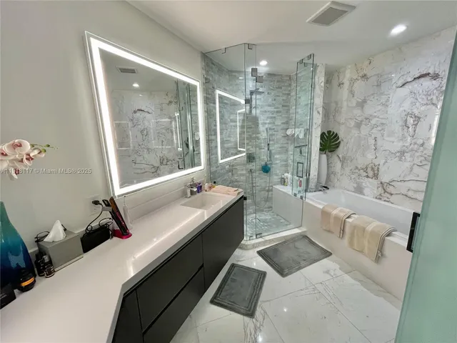 a bathroom with a granite countertop sink a toilet a mirror and shower