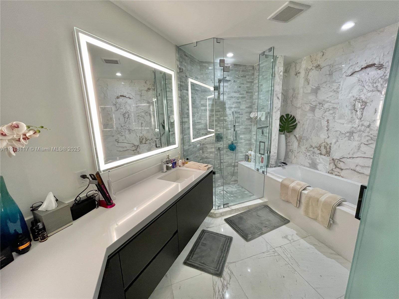 851 Northeast 1st Avenue, Unit 2605 Miami, FL 33132 - Photo 10 of 49 a bathroom with a granite countertop sink a toilet a mirror and shower
