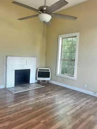 a view of an empty room with a fireplace and a window
