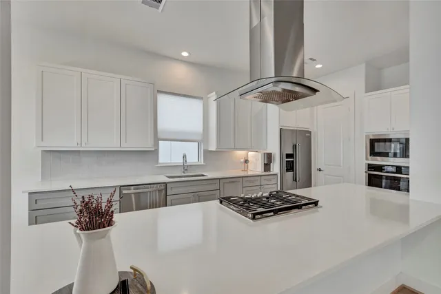 a kitchen with stainless steel appliances a stove a sink and a refrigerator