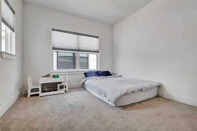 a spacious bedroom with a bed and a window