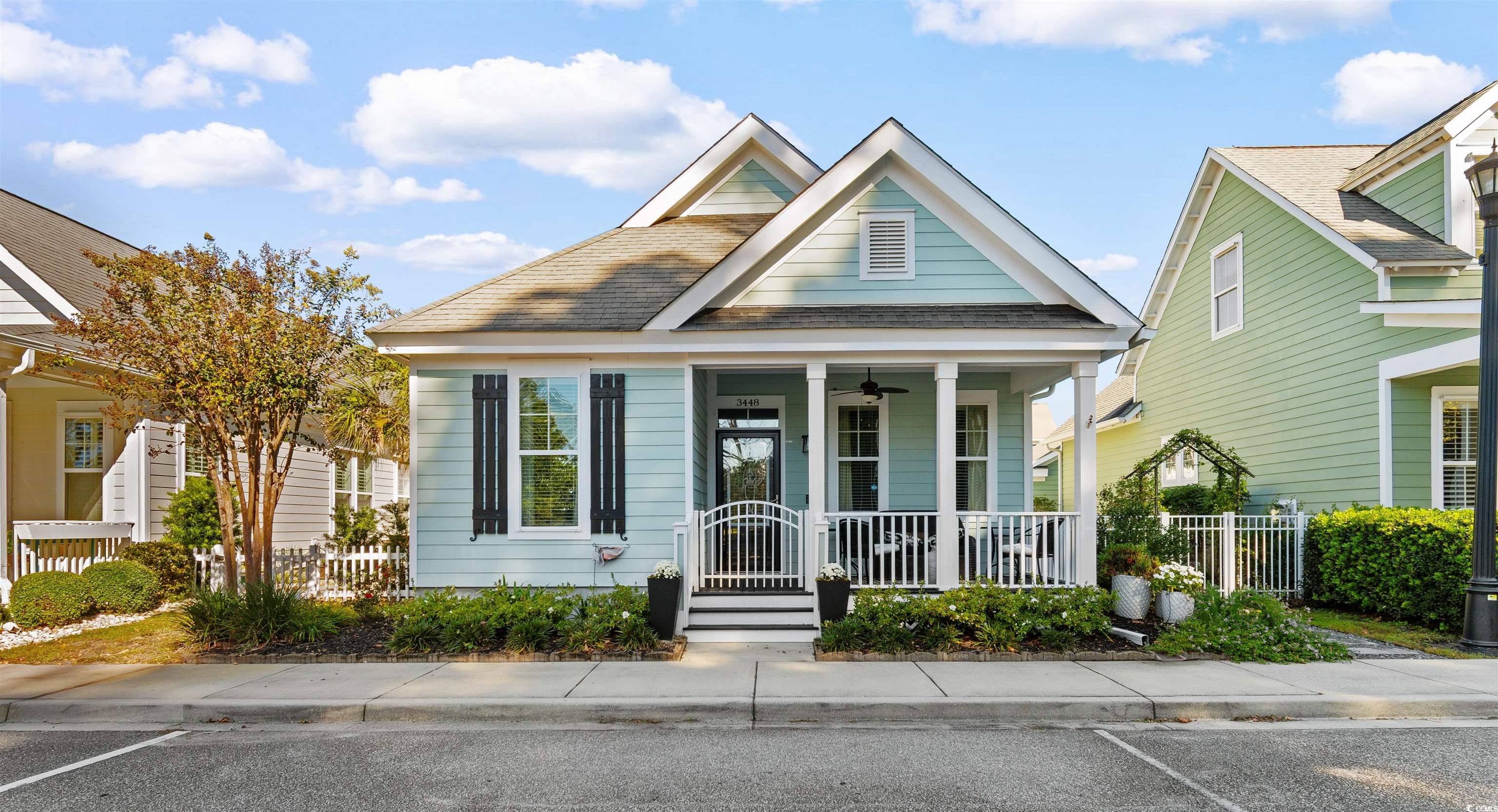 View of front facade featuring covered porch, a shingled roof, and uncovered parking