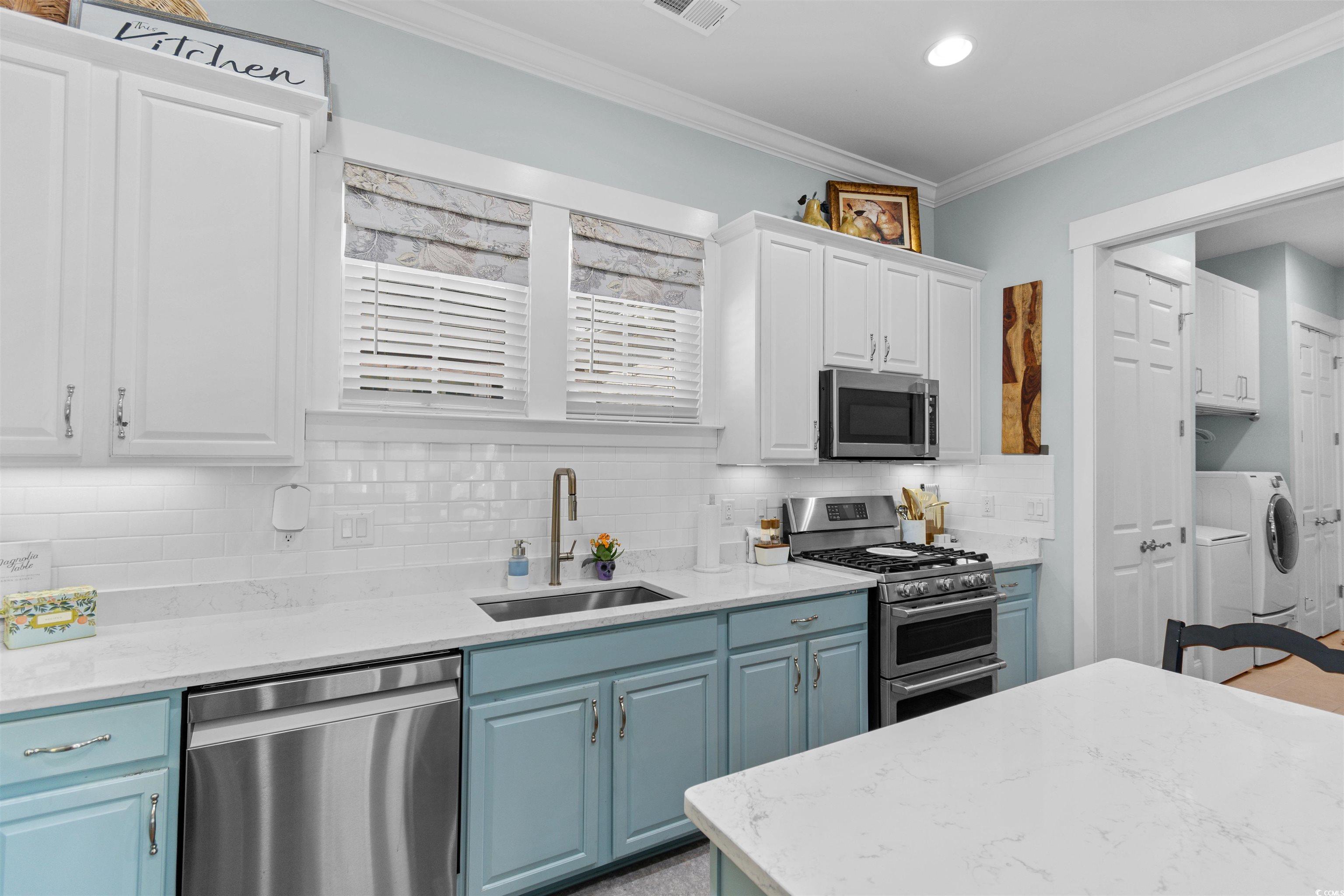 3448 Baldwin Lane Myrtle Beach, SC 29577 - Photo 5 of 30 Kitchen with crown molding, appliances with stainless steel finishes, blue cabinetry, light stone countertops, and white cabinets