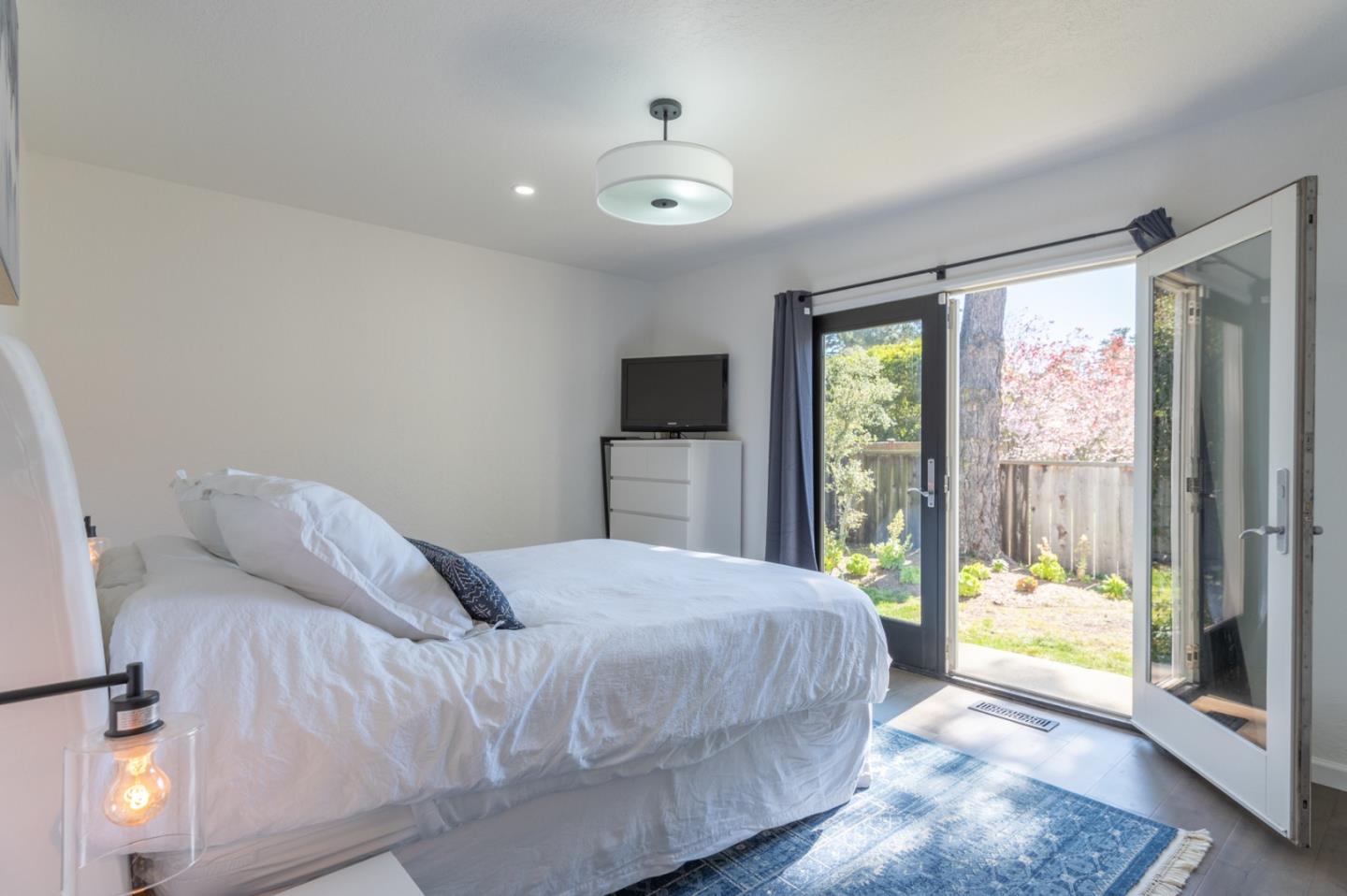 3039 Sloat Road Pebble Beach, CA 93953 - Photo 29 of 34 a bedroom with a bed and glass door