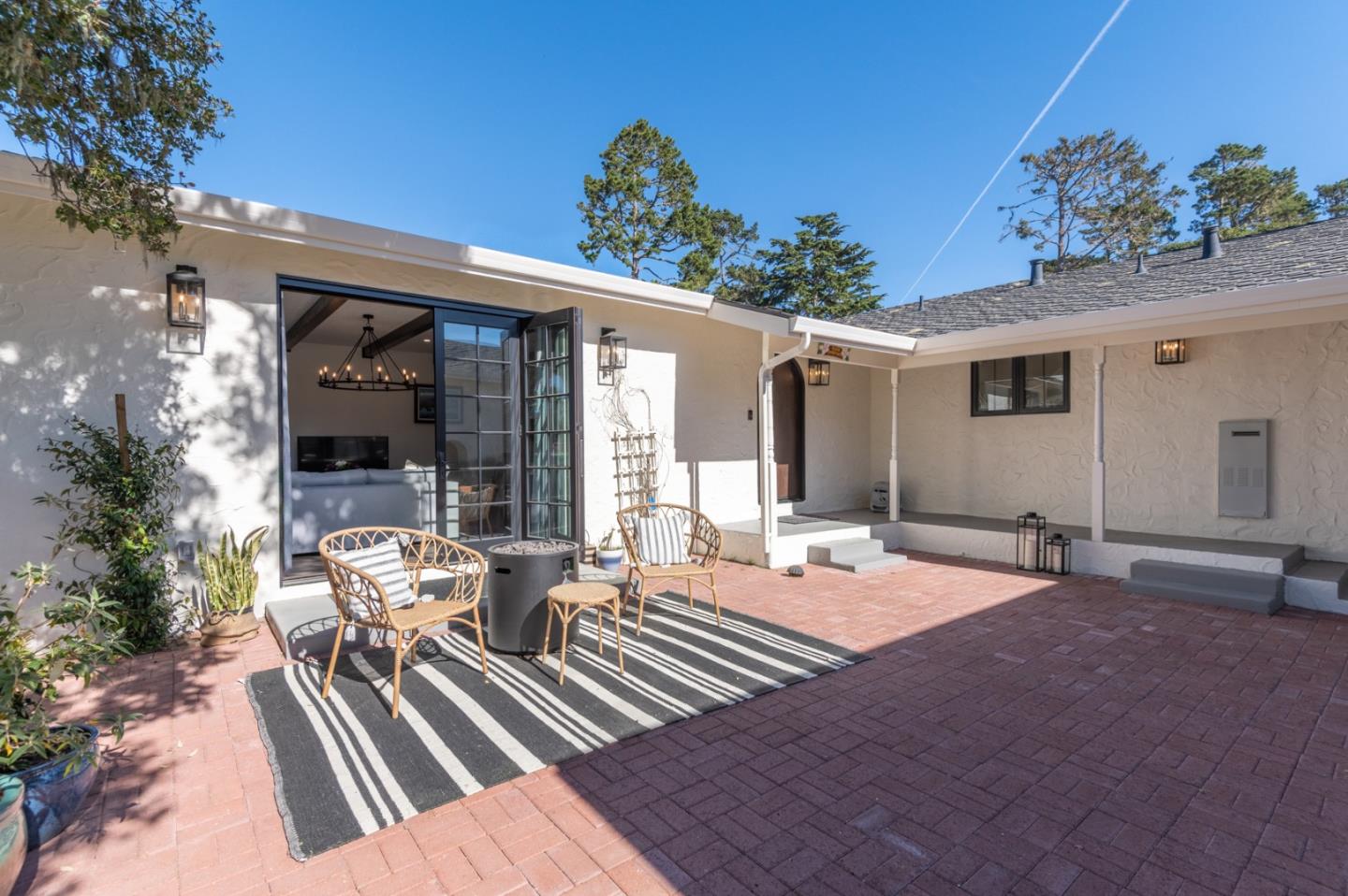 3039 Sloat Road Pebble Beach, CA 93953 - Photo 5 of 34 a view of a patio with table and chairs potted plants and floor to ceiling window