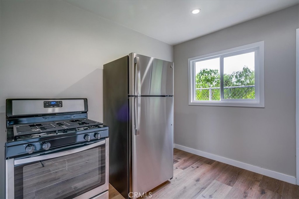 323 Culver Boulevard Playa del Rey, CA 90293 - Photo 20 of 58 a kitchen with stainless steel appliances granite countertop a refrigerator stove and wooden floor