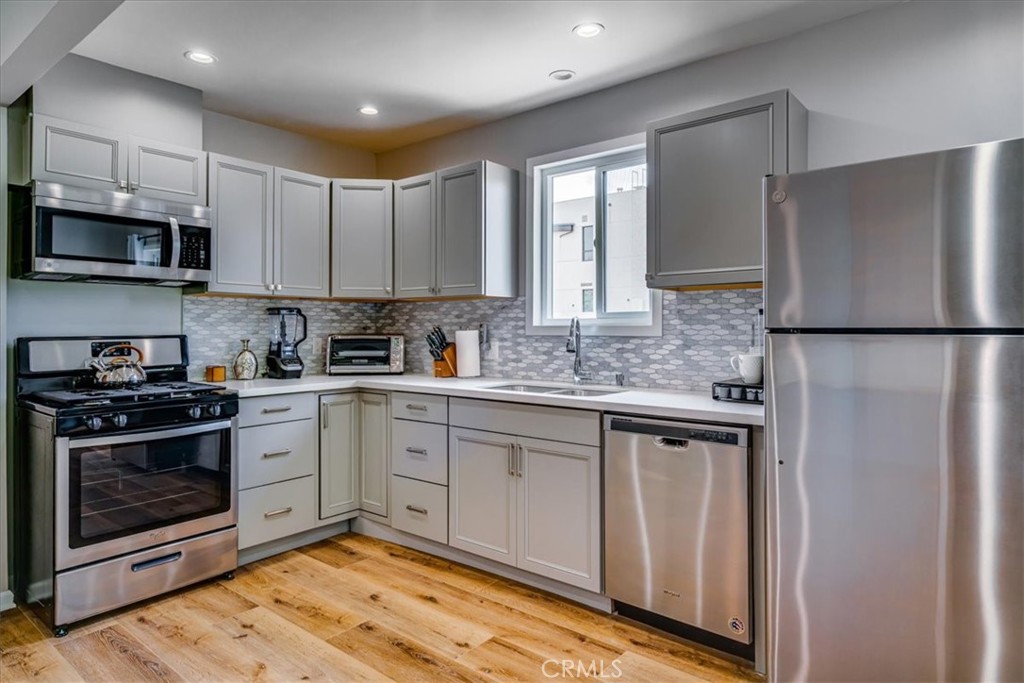323 Culver Boulevard Playa del Rey, CA 90293 - Photo 53 of 58 a kitchen with stainless steel appliances granite countertop a stove a refrigerator and a sink