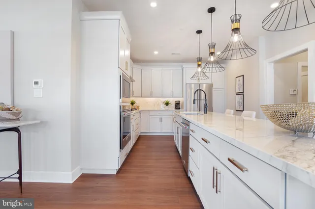 a large kitchen with granite countertop a sink stainless steel appliances and cabinets