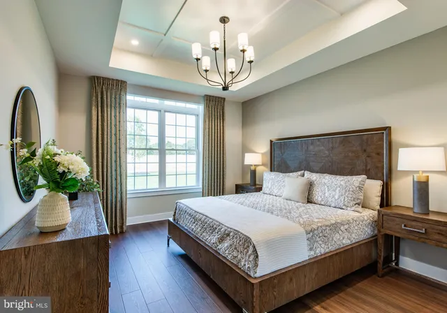 a bedroom with bed a chandelier and a window