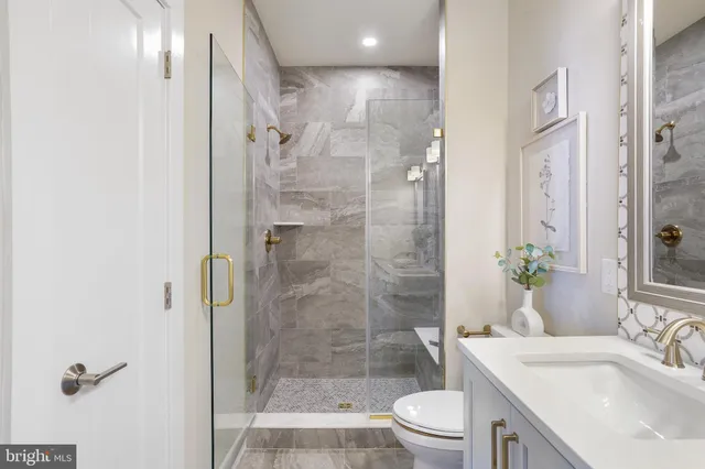 a bathroom with a sink a toilet and shower