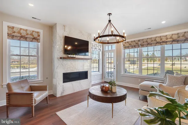 a living room with fireplace a flat screen tv and a large window