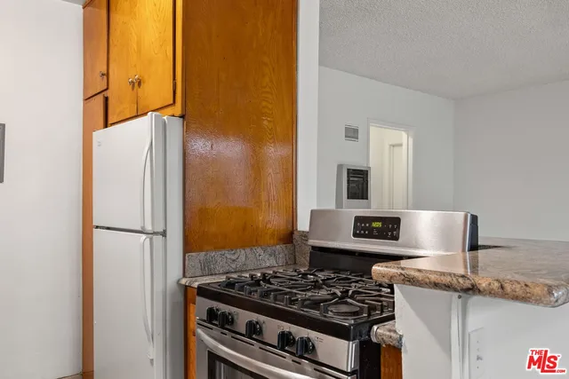 a kitchen with stainless steel appliances granite countertop a refrigerator and a stove