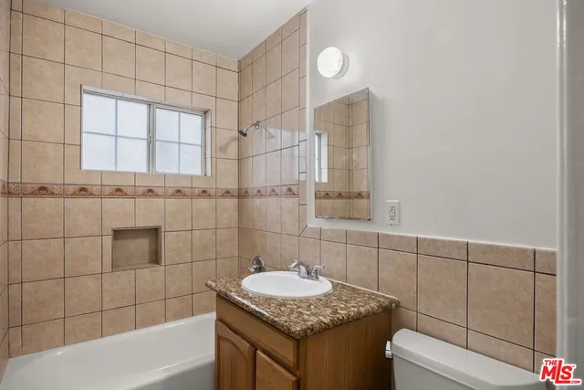 a bathroom with a granite countertop sink and mirror